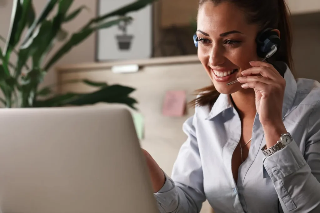 Conseillère support client souriante avec casque audio, offrant une assistance rapide aux clients d'un revendeur IPTV

