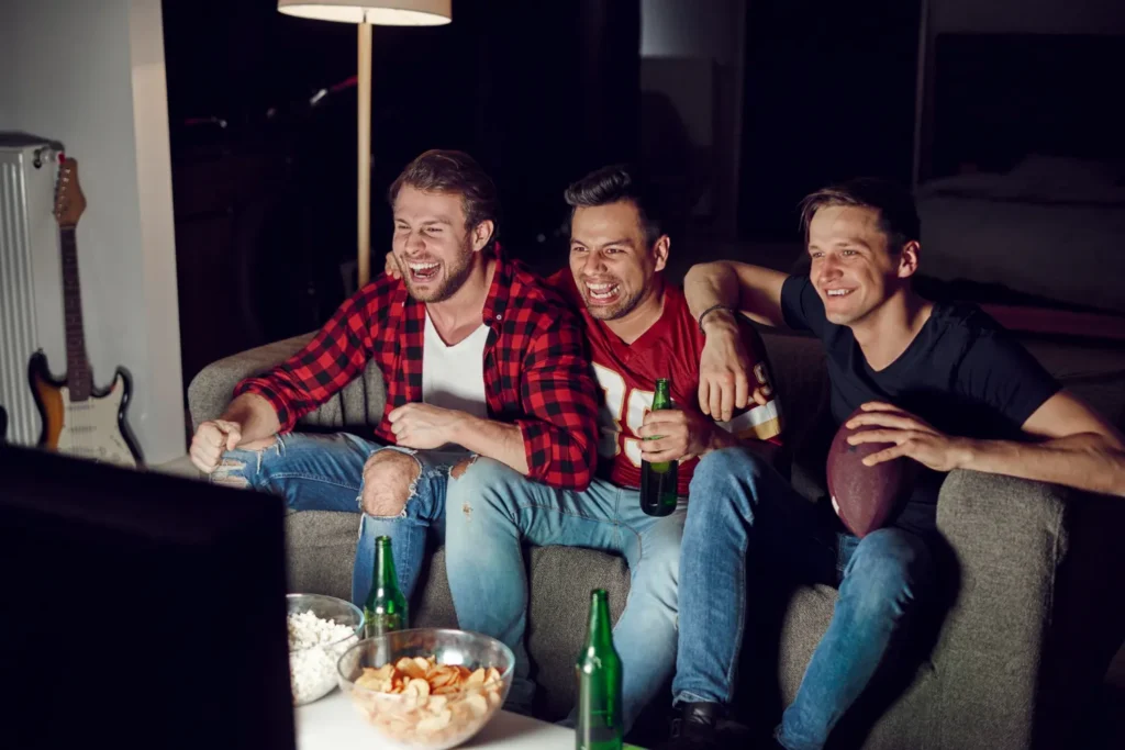 Amis regardant un match de sport en direct grâce à un abonnement IPTV pas cher en Belgique