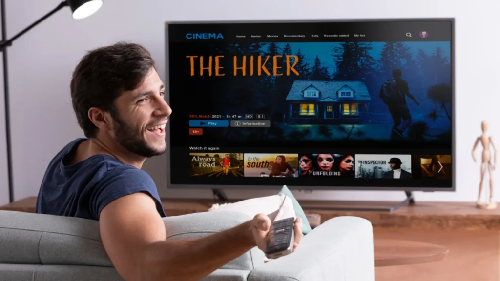 Homme regardant le meilleur abonnement IPTV sur Smart TV en salon